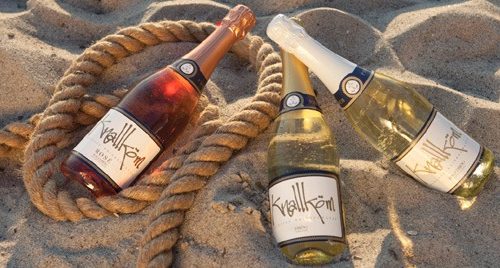 3 verschiedene Knallkömflaschen im Strandsand